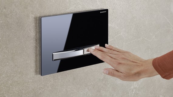 Ar roku nospiežot mazā noskalošanas režīma pogu uz Geberit Sigma50 noskalošanas paneļa Ar roku nospiežot mazā noskalošanas režīma pogu uz Geberit Sigma50 noskalošanas paneļa