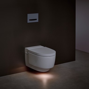 Geberit AquaClean Mera bidē tualetes pods ar vāku ar ieslēgtu orientācijas gaismu Geberit AquaClean Mera bidē tualetes pods ar vāku ar ieslēgtu orientācijas gaismu