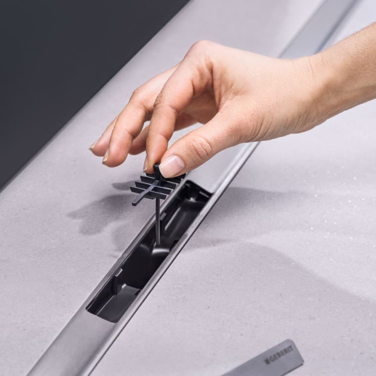 Ar roku ievietojiet ķemmveida ieliktni notecē Ar roku ievietojiet ķemmveida ieliktni notecē